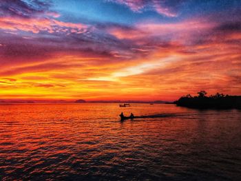 Scenic view of sea against dramatic sky during sunset