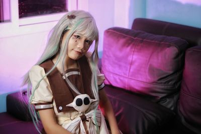 Young woman sitting on sofa at home