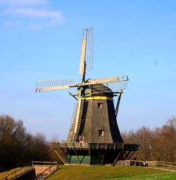 Traditional windmill on field against sky