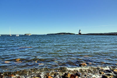 Scenic view of sea against clear blue sky
