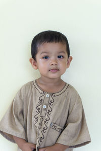 Portrait of cute boy against wall