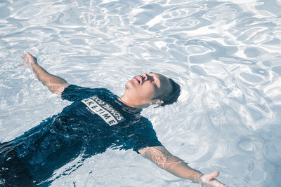 High angle view of woman lying in swimming pool