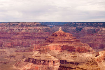 Rock formations on landscape against cloudy sky