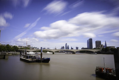 Scenic view of river by buildings against sky