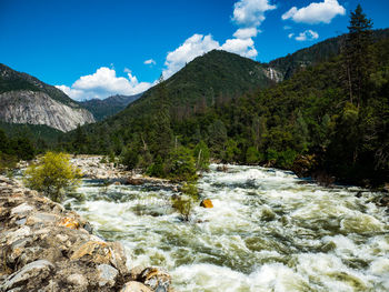 Scenic view of river and mountains against sky