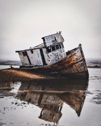 Abandoned ship in sea against sky