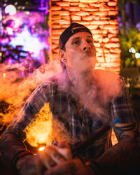 Portrait of young man smoking cigarette