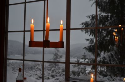 Close-up of illuminated lamp against sky during winter