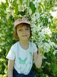 Portrait of girl standing against plants