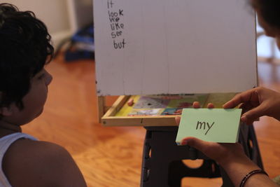 Rear view of girl writing on board