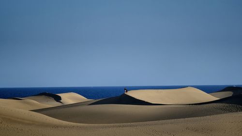 Scenic view of desert against clear blue sky