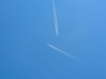 Low angle view of airshow against clear blue sky