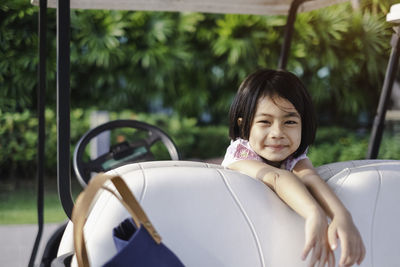 Portrait of smiling girl on golf cart