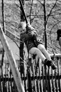 Low angle view of boy on swing at playground
