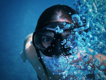 Close-up of a woman rising from the abyss in the middle of the bubbles.