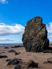 Rock formation on beach against sky