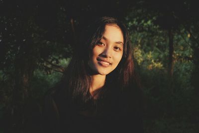 Portrait of smiling young woman in forest