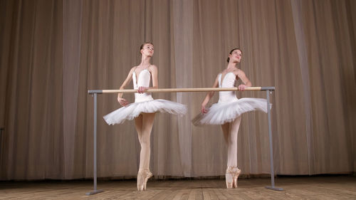 Ballet rehearsal, in old theater hall. young ballerinas in white ballet skirts, tutus