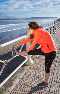Rear view of woman looking at sea shore against sky