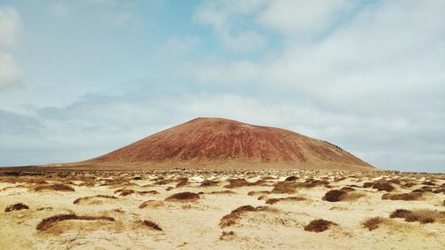 View of desert against cloudy sky