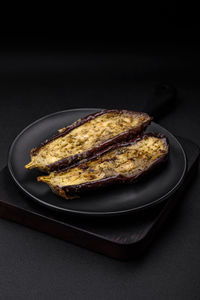 Close-up of food in plate on table against black background