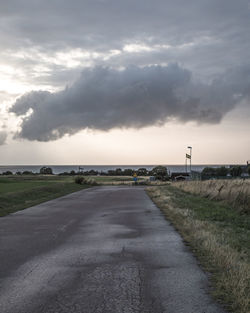 Road by landscape against sky