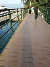 Rear view of people standing on footbridge