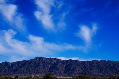 Scenic view of mountains against blue sky