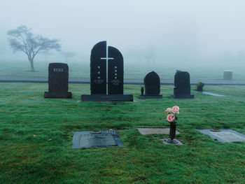 Woman in cemetery against sky