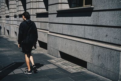 Full length rear view of woman walking on wall