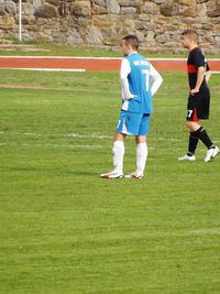 People playing soccer on grassy field