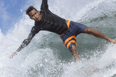 Portrait of carefree man surfing on sea