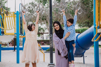 Mother with cheerful daughters enjoying at park