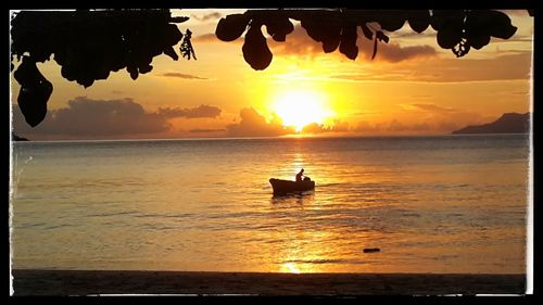 Silhouette boat in sea against sky during sunset