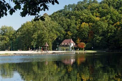 Swimming pool by lake against sky