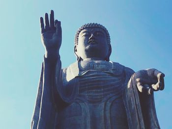 Low angle view of statue against temple against sky