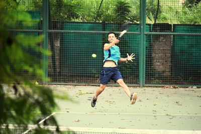 Full length of young man playing tennis