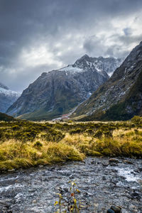 Scenic view of lake by mountains against sky