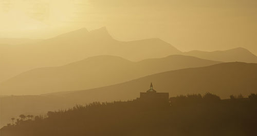 Scenic view of silhouette mountains against sky during sunset