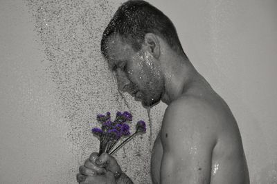 Side view of man bathing with flowers