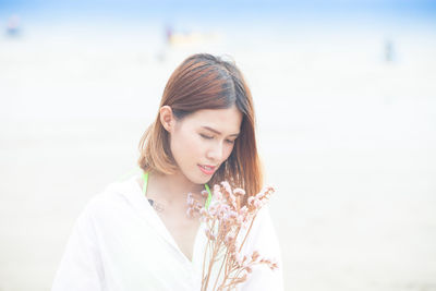 Close-up of young woman with eyes closed standing against blurred background