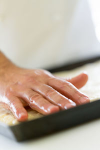 Cropped hand of man preparing food on table