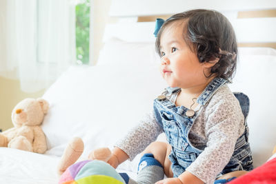 Cute girl sitting with toy at home