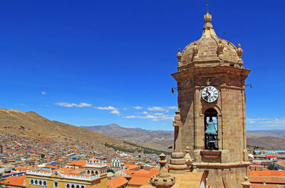 Clock tower of building against blue sky