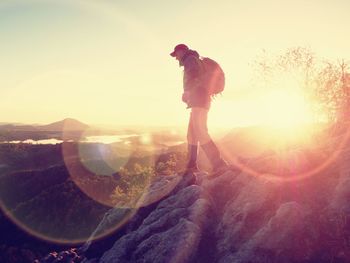 Man achieve the summit. man on peak alone with his minds. sunset and cloudy wheather, sun flares 