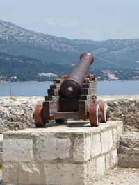 Cannon by sea against sky