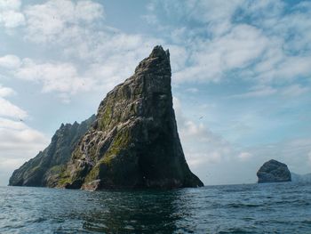 Scenic view of sea by cliff against sky