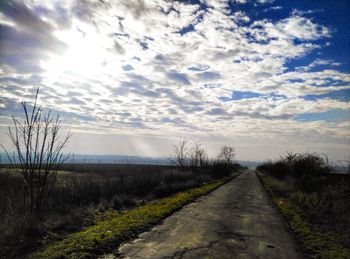 Road by landscape against sky