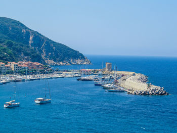 Sailboats in sea against clear sky