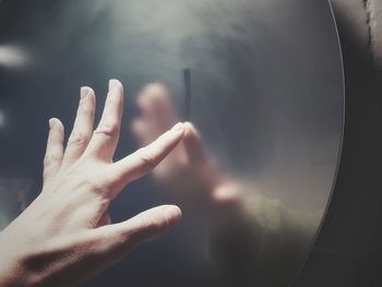 Close-up of hand touching metal